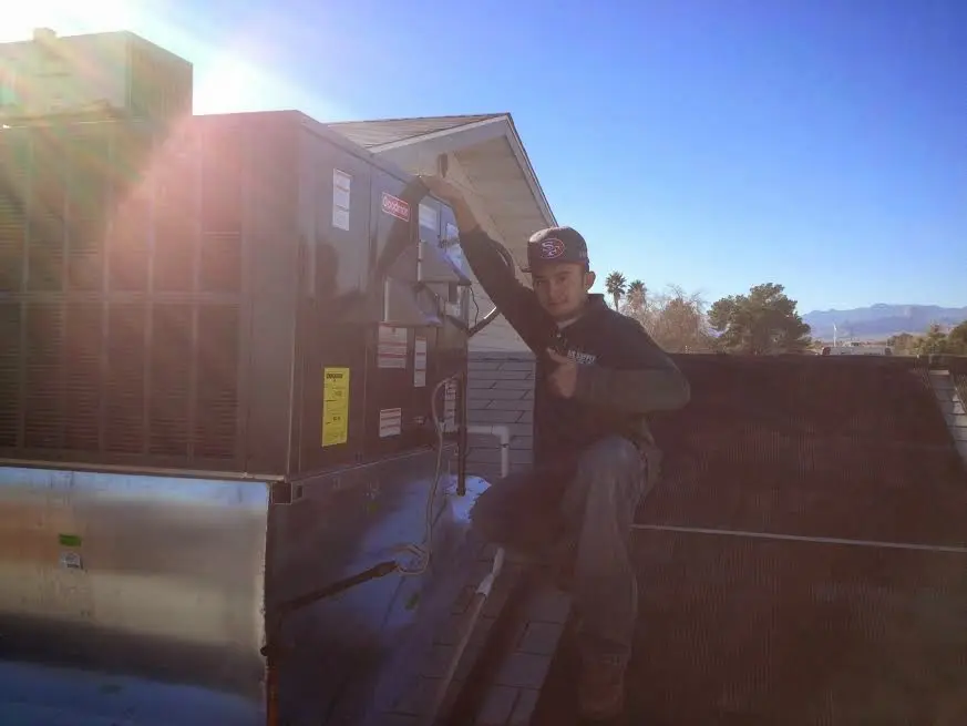 HVAC technician performing AC Tune-Up on a rooftop unit in Kokomo